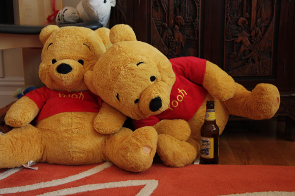 Two Pooh Bears, with bottle of beer toppled