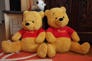 Two Pooh Bears sitting next to each other