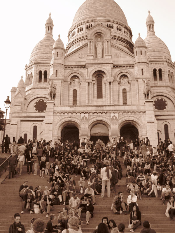 People sitting on the steps infront of Sacre Coeur