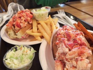 Two lobster rolls with chips and coleslaw