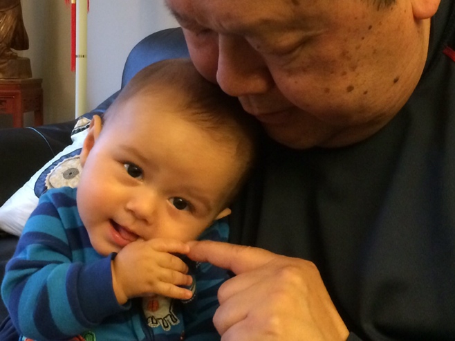 Baby and grandpa touching fingers