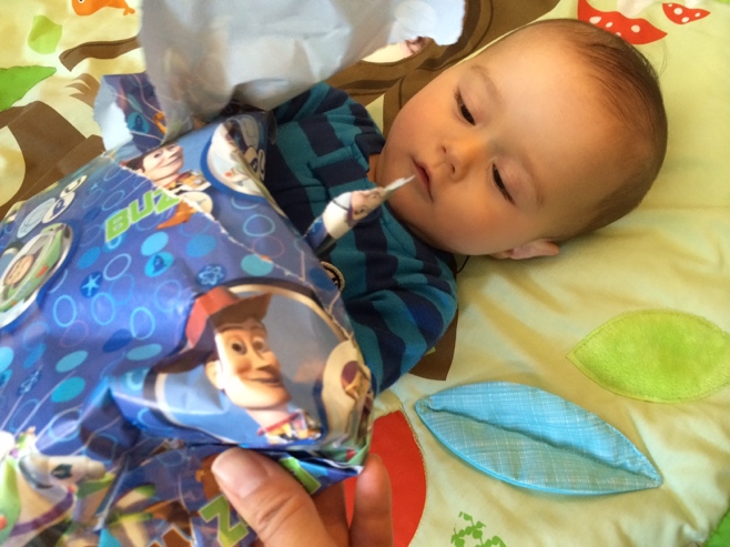 Baby helping to unwrap presents