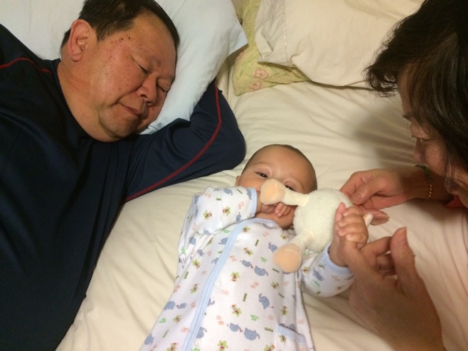 Baby in bed with grandparents