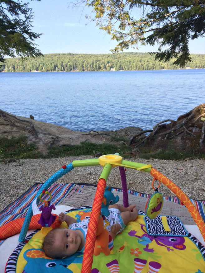 Nany on activity mat in front of lake