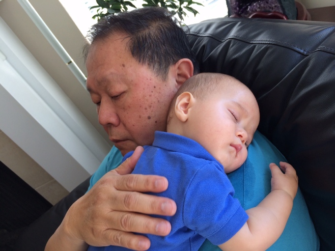 Baby sleeping on grandpas shoulder