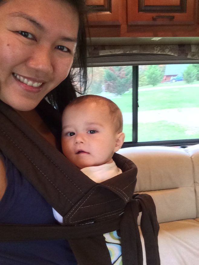 Baby strapped to mum in a sling in an RV