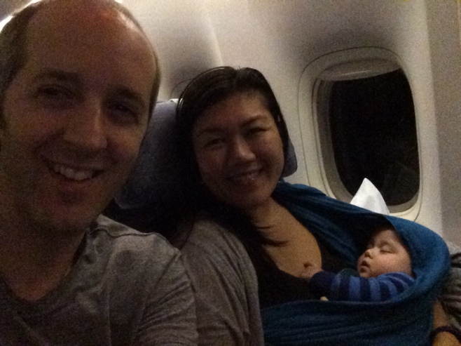 Mum dad and sleeping baby on a plane