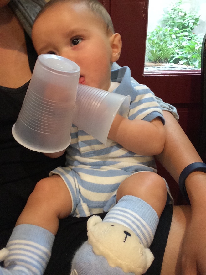 Baby with plastic cups on his hands