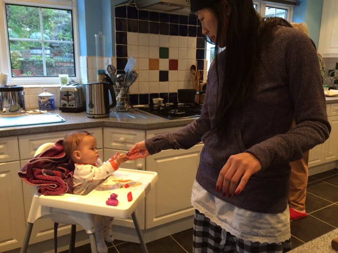 Woman giving baby food at breakfast