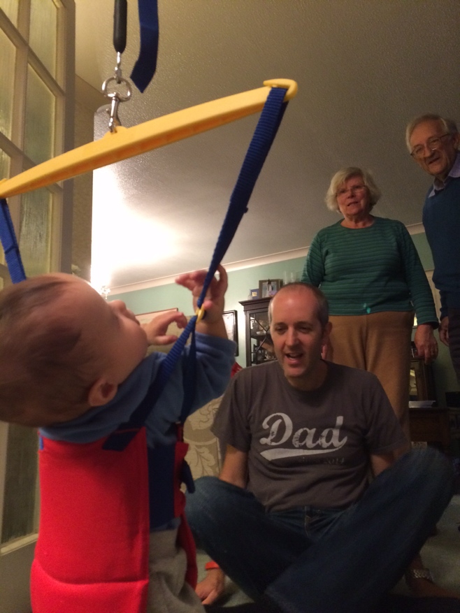 Baby in a bouncer watched by grandparents