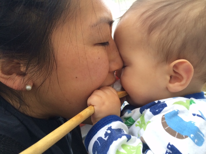 Woman and baby with wooden spoon in mouth