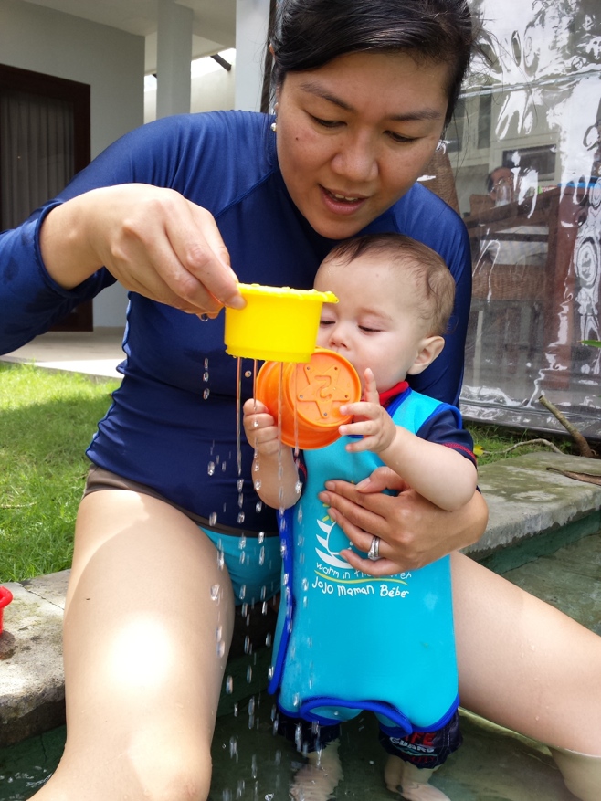 Baby and mum playing with water in pots