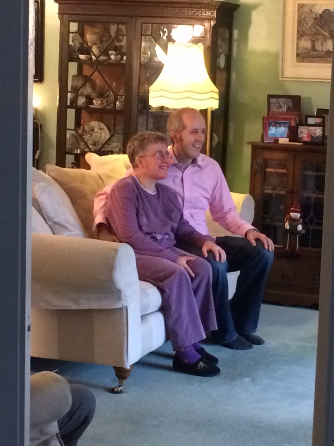 Man and woman on couch posing for photographs