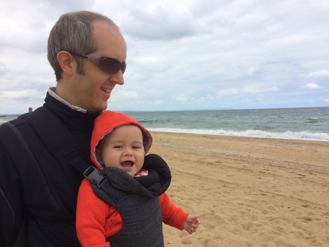 Man and laughing baby on the beach