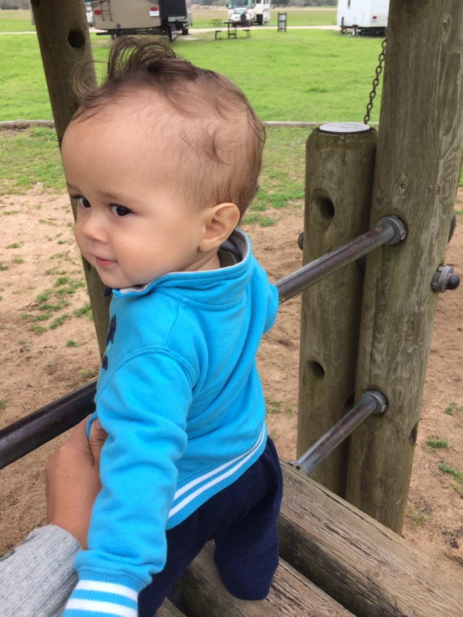 Baby standing on play equipment