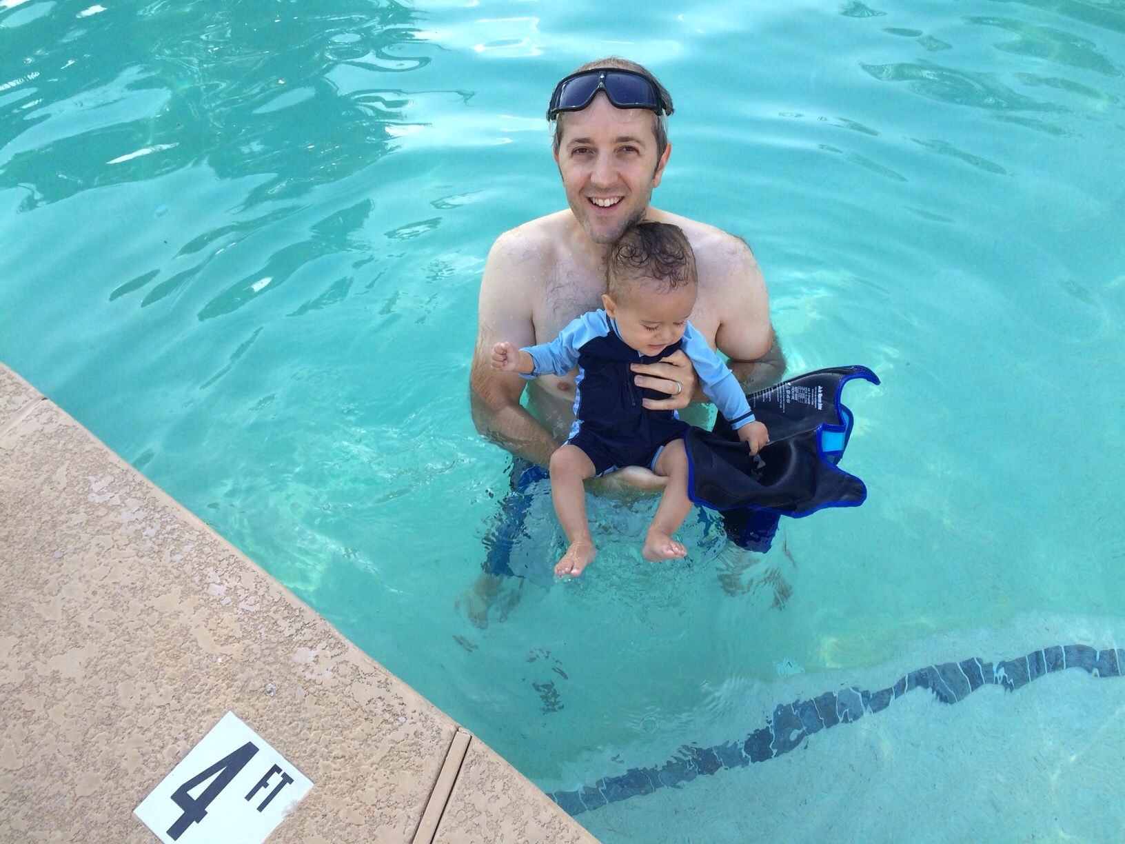 English hubby holding baby boy o in the pool 